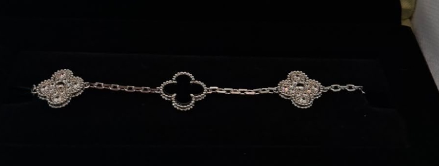 Pulsera de motivos de trébol negro dentro de su estuche.